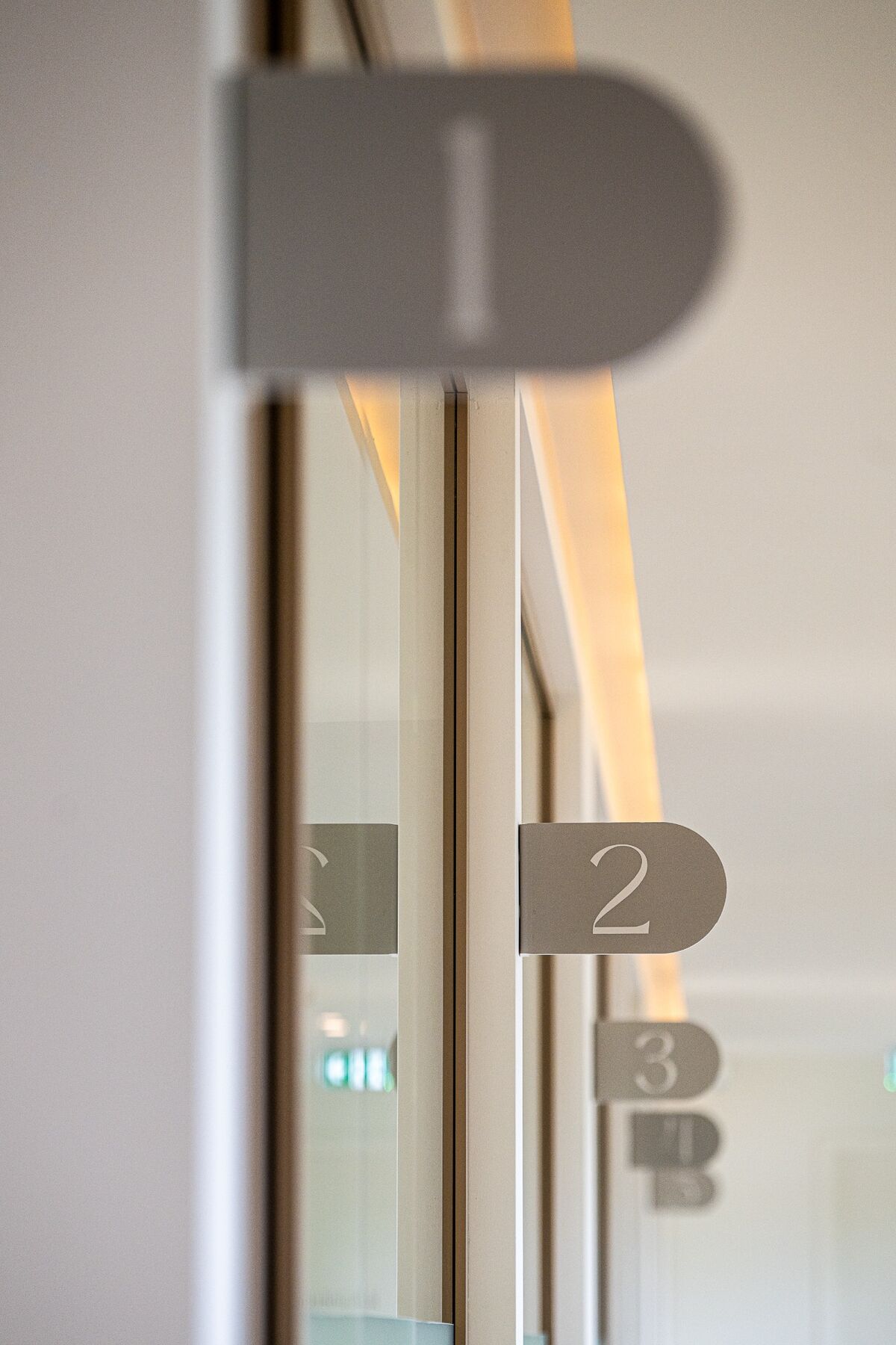 Detail van maatwerk kamernummering op glazen puien
